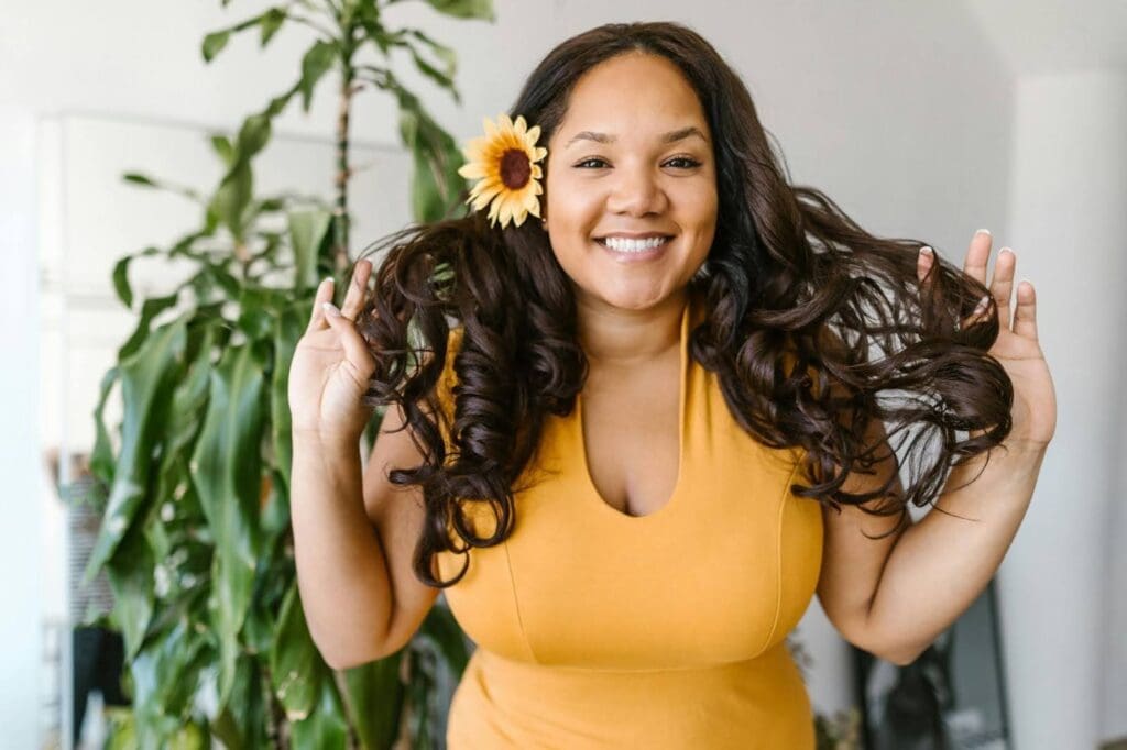 Woman smiling confidently and embracing body trust and body neutrality, representing a positive shift from body negativity to body image acceptance.