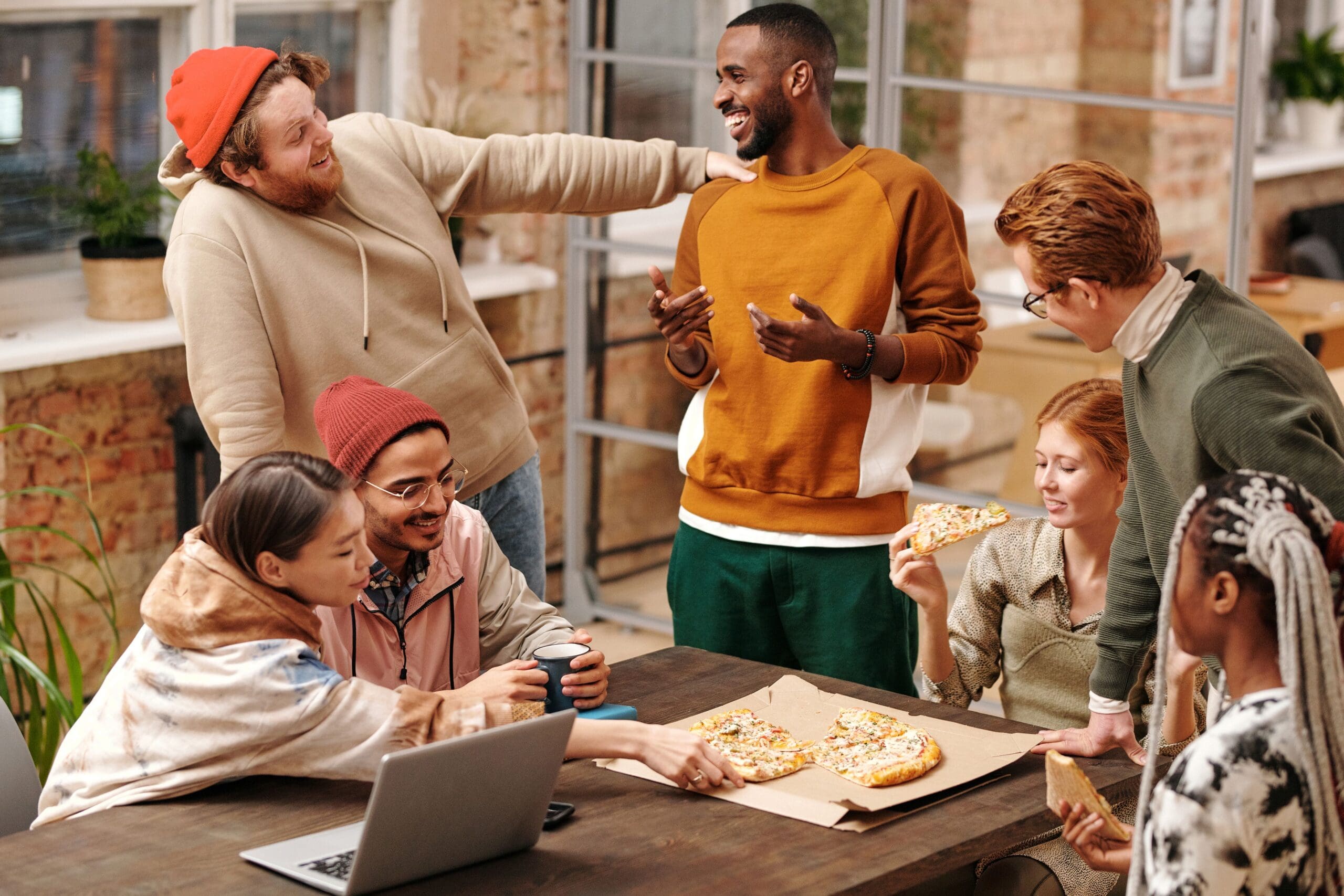 Diverse group of friends sharing pizza together, showing relaxed, social eating without food restriction